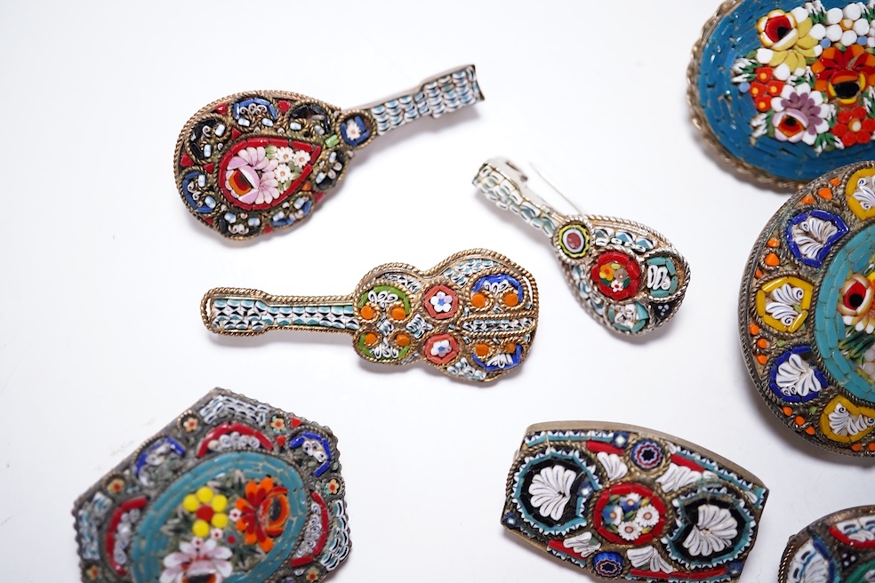 A collection of twenty-five micro-mosaic costume jewellery brooches. Including thirteen banjo and guitars shaped brooches, six large oval and circular brooches and six smaller brooches. Condition - mostly good